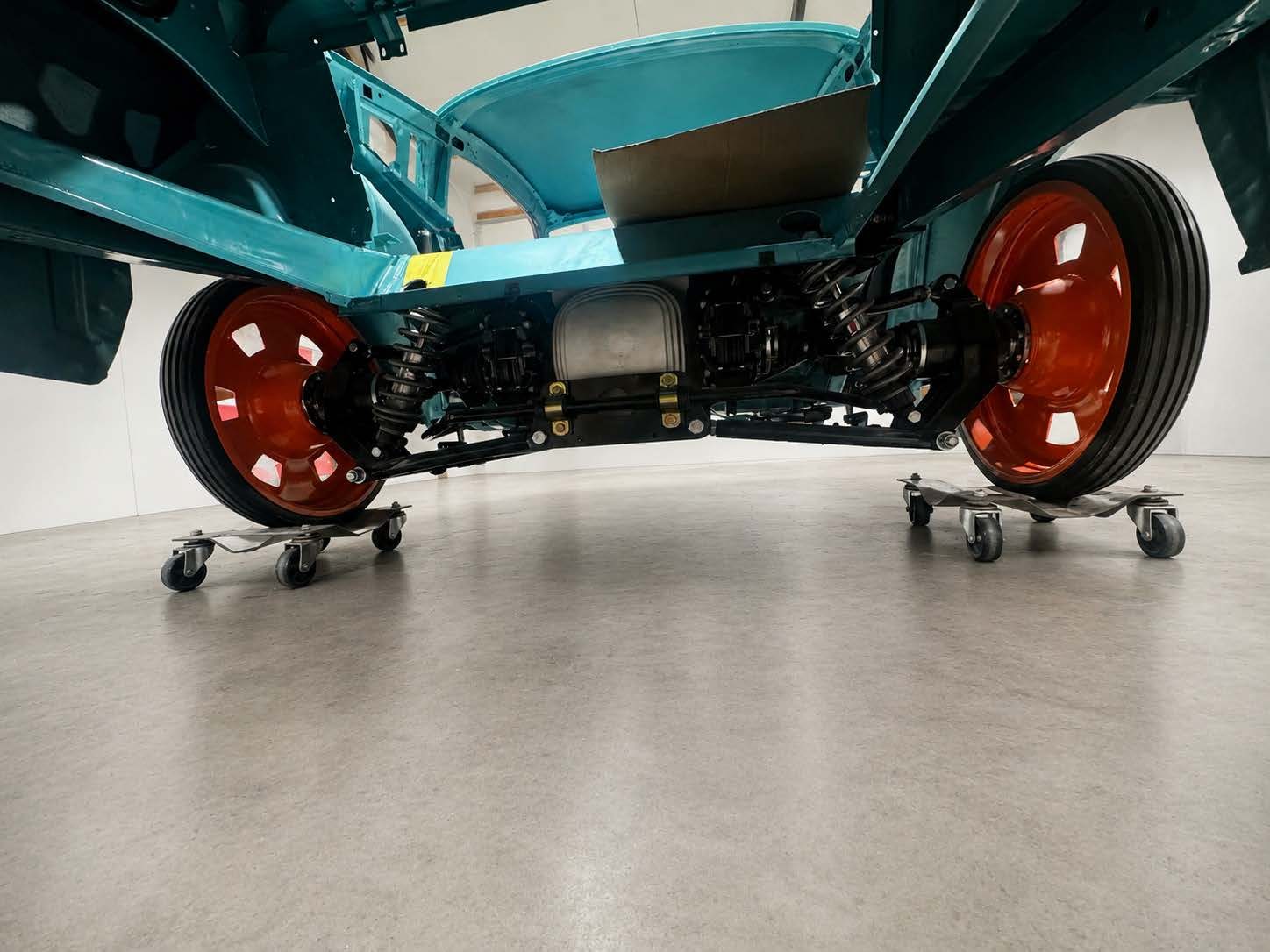 Rolling Mustang chassis on dollies, painted underside and red wheels