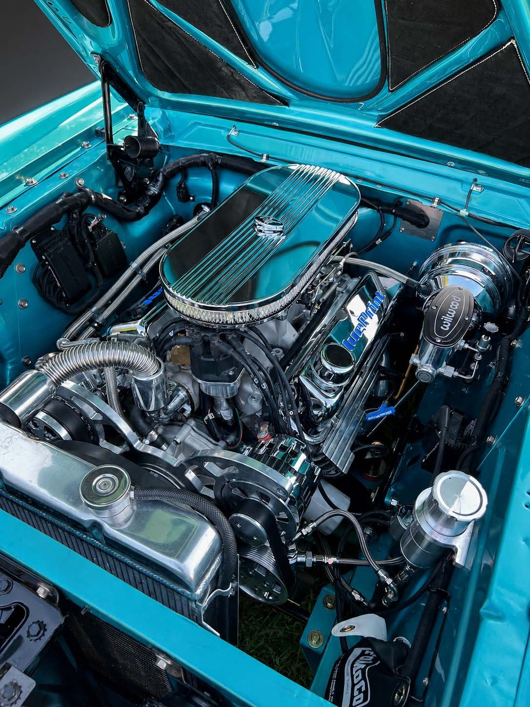 Polished V8 engine bay in a teal Mustang